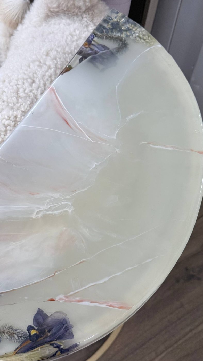 Крупный план столешницы столика «Оникс»: молочно-белая заливка с розовыми прожилками и натуральными цветами по краю